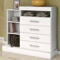 a white dresser with drawers and pictures on it