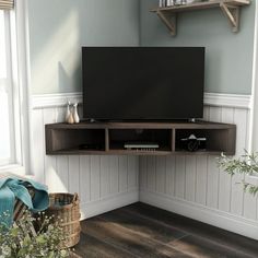 a flat screen tv sitting on top of a wooden shelf