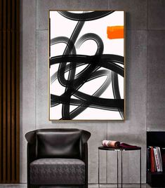 an abstract painting hangs on the wall above a chair and side table in a modern living room