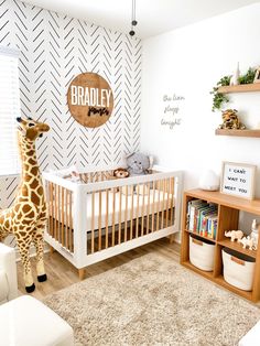 a baby's room with a giraffe stuffed animal in the crib