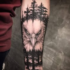 an eagle and trees tattoo on the arm