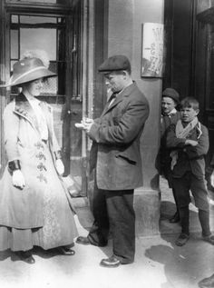 an old black and white photo of people standing in front of a building with glass doors