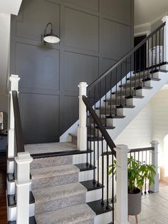 a staircase leading up to the second floor in a house with gray walls and white trim