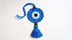 a blue tasseled keychain with an evil eye on it