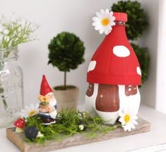 two gnomes are sitting on a shelf next to some plants