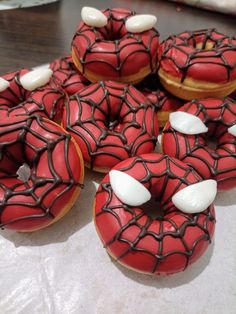 spiderman donuts with white frosting and sprinkles are on the table