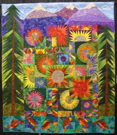 a colorful quilt with trees and mountains in the background