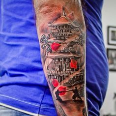 a man with a tattoo on his arm is standing in front of a clock tower