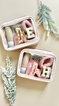 two tins filled with different types of items on top of a white table next to a christmas tree