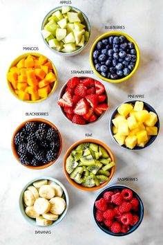 bowls filled with different types of fruit on top of a white countertop next to each other