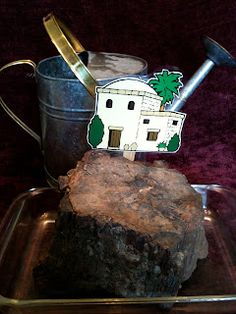 a piece of wood sitting on top of a metal pan next to a cup and shovel