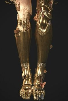 the legs and feet of a statue are covered in gold leafy decorations, including flowers