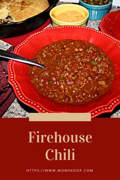 a red bowl filled with chili next to other dishes