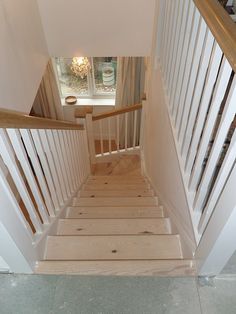 the stairs are made of wood and have white painted railings on them, along with glass flooring