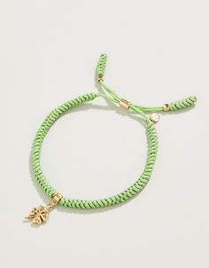 a green rope bracelet with a gold charm on the end and a star charm at the end