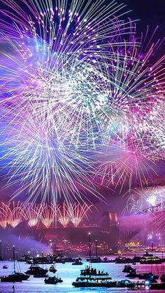 fireworks are lit up in the sky above boats