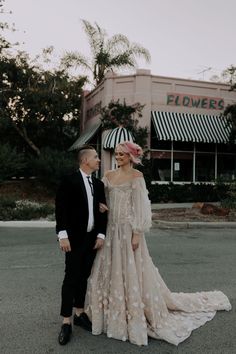 a man and woman standing next to each other in front of a building