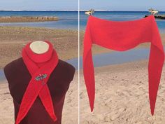 a red knitted scarf hanging from a mannequin's head on the beach