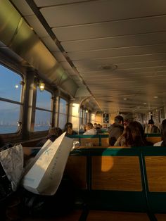 people are sitting on the inside of a train looking out the window at the ocean