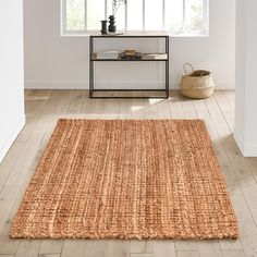 an area rug in the middle of a room with white walls and wooden flooring