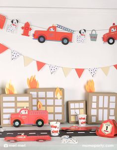 a birthday party with firetrucks, cars and paper decorations on the table