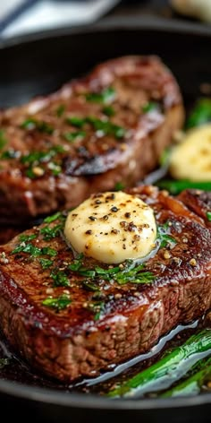 steak and asparagus on a black plate with some sauce in the middle, ready to be eaten