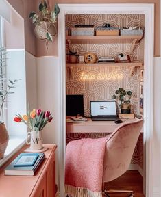 a desk with a laptop on top of it next to a shelf filled with books