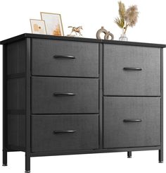 a black dresser with drawers and pictures on top