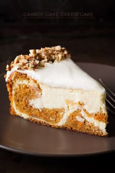 a piece of carrot cake with white frosting and walnuts on top, sitting on a black plate