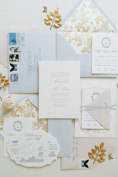 the wedding stationery is laid out on top of each other with gold and silver accents