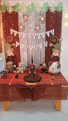 a table topped with lots of stuffed animals next to a wall covered in streamers