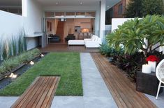 an outdoor living area with wooden benches and plants