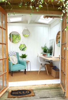 an open door leading into a room with plants on the wall and a desk in the corner