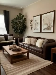 a living room with couches, coffee table and pictures on the wall above them