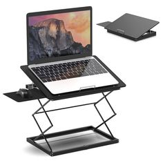 an open laptop computer sitting on top of a metal stand next to a black tray