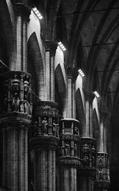 black and white photograph of the interior of a cathedral with columns, arches and statues