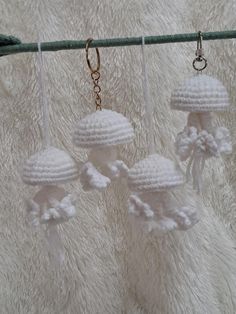 three white crocheted objects hanging from a line