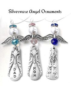 three silver angel ornaments with blue and white beads on them, hanging from a chain