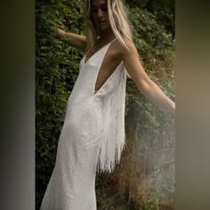 a woman in a white dress is posing for the camera with her arms spread out