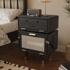 an old fashioned radio sits on a nightstand next to a bed with black headboard and foot board