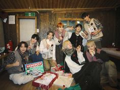 a group of young people posing for a photo in a room with presents on the floor