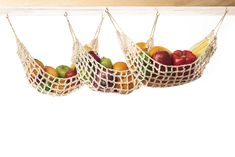 three baskets filled with fruit sitting on top of a wooden shelf