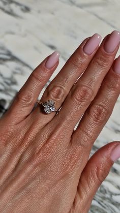 a woman's hand with pink manies and a ring on her left hand