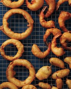 fried shrimp rings and onion rings on a cooling rack