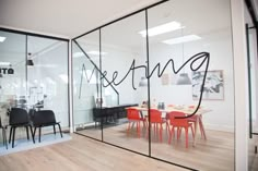 an office with glass walls and chairs in front of the window that says meeting on it