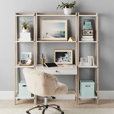 a white desk chair sitting in front of a book shelf filled with books and pictures