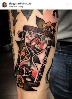 a tattoo with an hourglass and flowers on the arm, which is in color