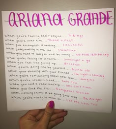 a hand holding up a piece of paper with writing on it that says ariana grade