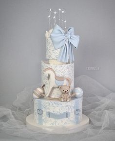 a three tiered cake decorated with blue and white decorations