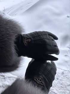 a pair of black gloves sitting on top of snow covered ground